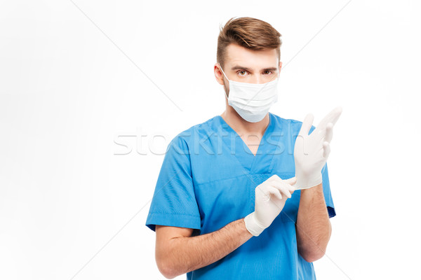 Male doctor putting on gloves  Stock photo © deandrobot