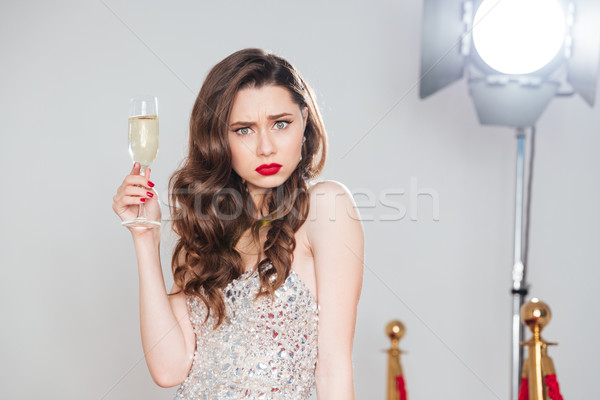 Angry woman holding glass of champagne Stock photo © deandrobot