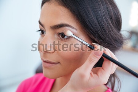 Hand of woman visagist applying eyeshadow to pretty young model  Stock photo © deandrobot