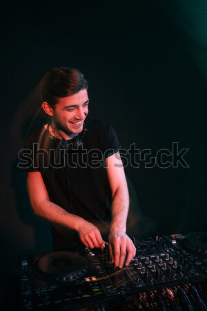 Dj standing and mixing tracks in nightclub Stock photo © deandrobot