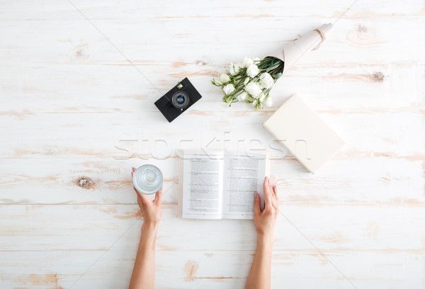 Women hands turn over book pages on the wooden desk Stock photo © deandrobot