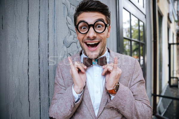 Cheerful funny young man in round glasses and wooden bowtie Stock photo © deandrobot
