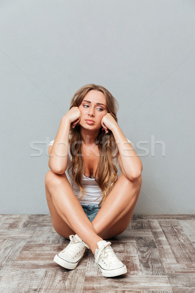 Cansado chateado mulher sessão as pernas cruzadas dor de cabeça Foto stock © deandrobot