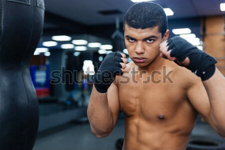 Tired boxer standing with punchbag. Stock photo © deandrobot