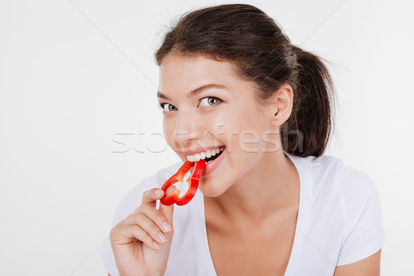 Portrait of happy young woman eating vegetables Stock photo © deandrobot