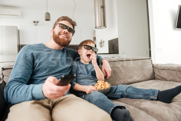 Surprised happy father watching TV with his little cute son Stock photo © deandrobot