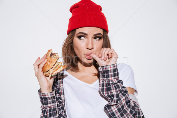 Fiatal éhes nő eszik hamburger portré Stock fotó © deandrobot