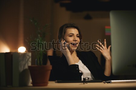 Happy young lady designer sitting in office at night Stock photo © deandrobot