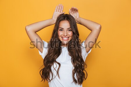 Girl in beachwear posing and keeping hands on her hat Stock photo © deandrobot