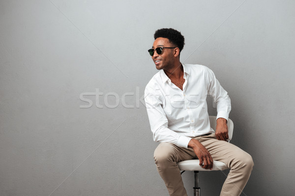 Stock photo: Happy young african man sitting in a chair