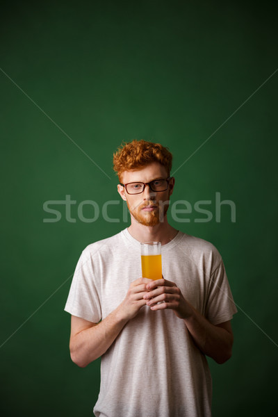 Portrait of a young redhead man holding glass of beer Stock photo © deandrobot