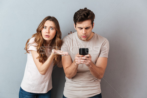 Portrait of a young couple standing with mobile phone Stock photo © deandrobot