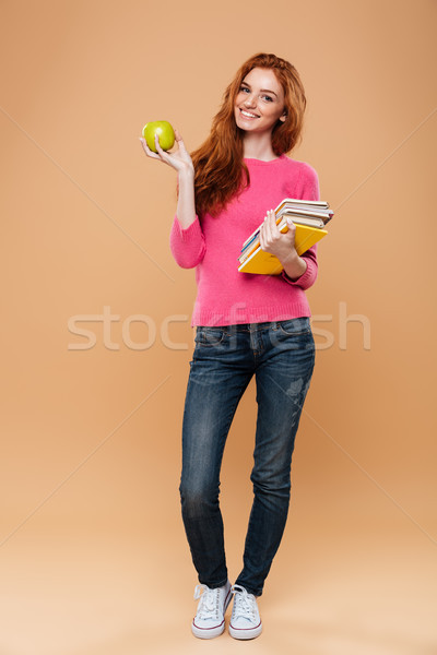 Full length portrait of a smiling pretty redhead girl Stock photo © deandrobot