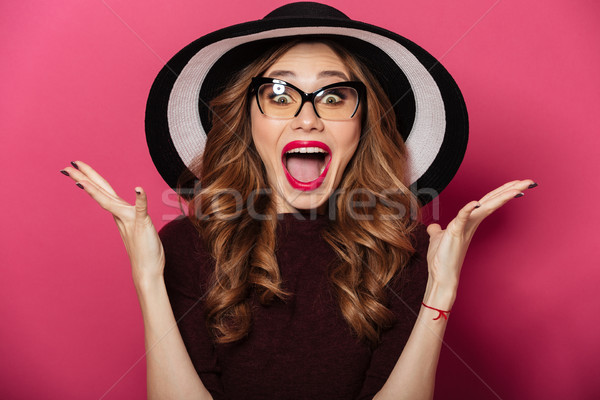 Young shocked lady wearing hat and glasses Stock photo © deandrobot