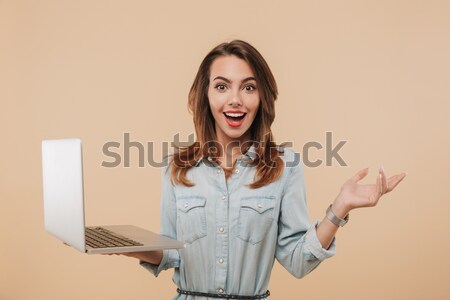 Happy exited attractive girl in warm clothes holding laptop comp Stock photo © deandrobot