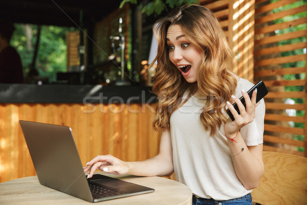 Stock photo: Portrait of a happy young girl holding mobile phone