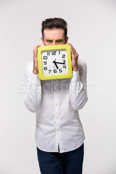 Businessman covering his face with wall clock Stock photo © deandrobot