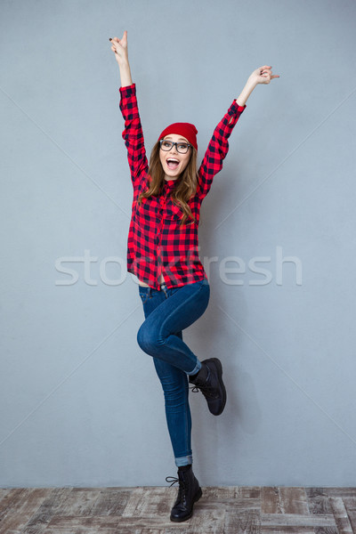 Alegre mulher posando as mãos levantadas para cima Foto stock © deandrobot