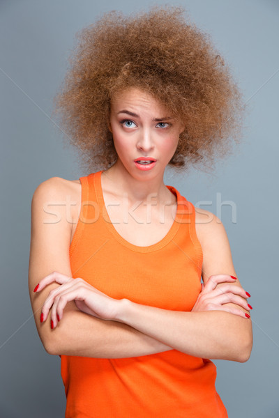 Mooie gekruld jonge vrouw geschokt poseren armen Stockfoto © deandrobot