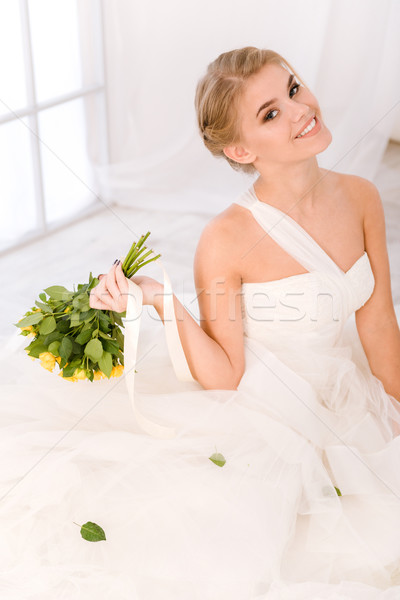 Smiling bride holding flowers Stock photo © deandrobot