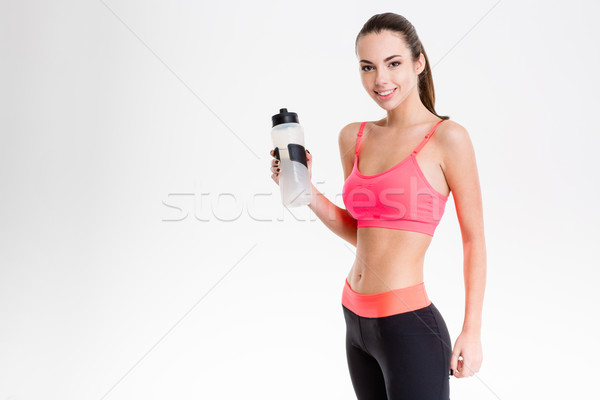 Pretty cute cheerful fitness girl holding a bottle of water  Stock photo © deandrobot
