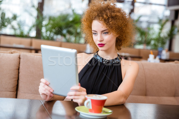 Woman using tablet computer in restaurant Stock photo © deandrobot