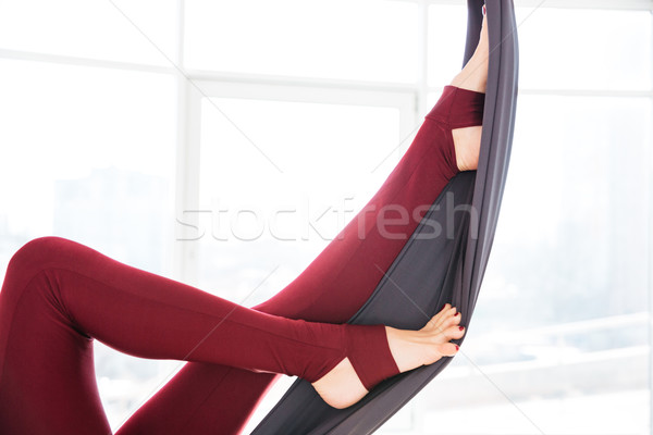 Legs of young woman in leggins using hammock at studio Stock photo © deandrobot