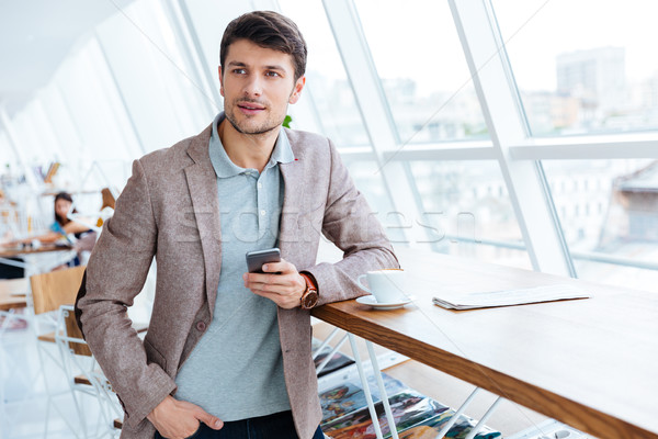 Mann Jacke halten Handy Mittagspause gut aussehend Stock foto © deandrobot