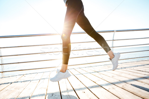 Cropped image of a runner woman feet in action Stock photo © deandrobot