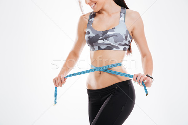 Cropped image of woman with measuring tape Stock photo © deandrobot
