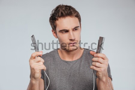 Stock photo: Portrait of a focused young man charging mobile phone