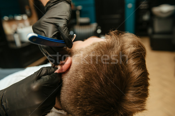 Photo of man getting beard shaving by hairdresser Stock photo © deandrobot