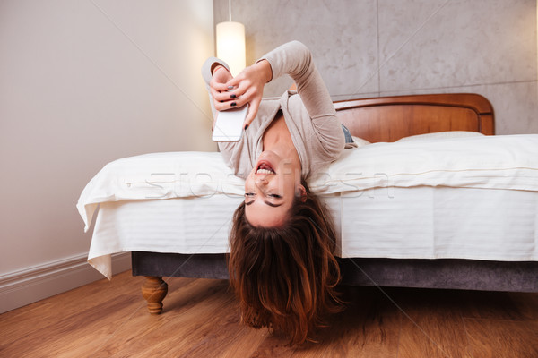 Kobieta do góry nogami bed mówić telefonu szczęśliwy Zdjęcia stock © deandrobot