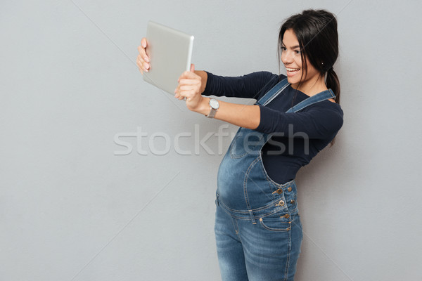 Happy pregnant woman make selfie by tablet computer Stock photo © deandrobot