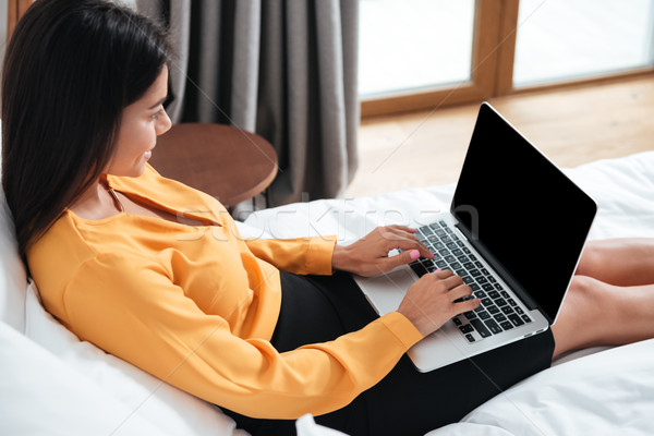 Widok z boku uśmiechnięty kobieta interesu laptop wpisując portret Zdjęcia stock © deandrobot
