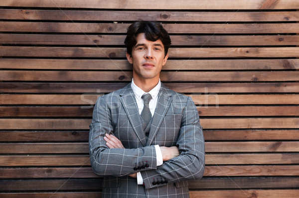 Lächelnd gut aussehend Geschäftsmann Anzug stehen Arme Stock foto © deandrobot
