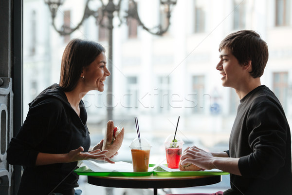 Smiling young man sitting in cafe with sister drinking juice Stock photo © deandrobot