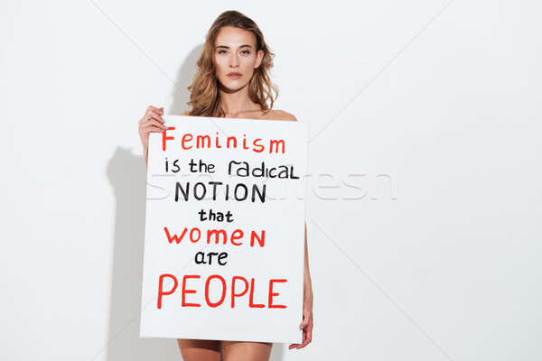 Naked young caucasian lady holding blank with text about feminism Stock photo © deandrobot