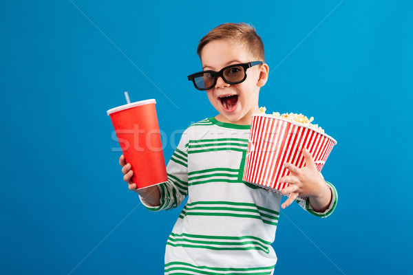 Cheerful young boy in eyeglasses preparing to watch the film Stock photo © deandrobot