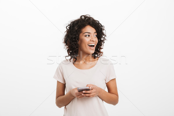 Communicating woman with afro hairstyle using mobile phone and l Stock photo © deandrobot