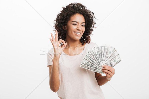 Successful american woman with curly dark hair holding fan of mo Stock photo © deandrobot