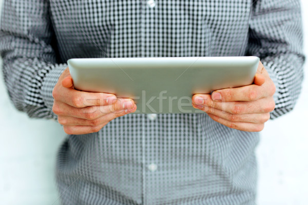 Closeup image of male hands holding tablet computer Stock photo © deandrobot