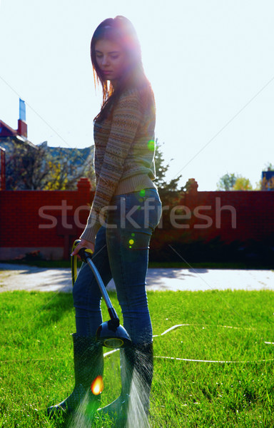 Full-length portrait of a woman is watering a garden Stock photo © deandrobot