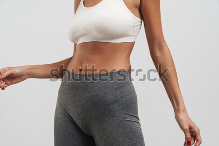 Slim woman's body over gray background Stock photo © deandrobot