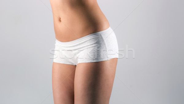 beautiful, slender female figure over gray background Stock photo © deandrobot
