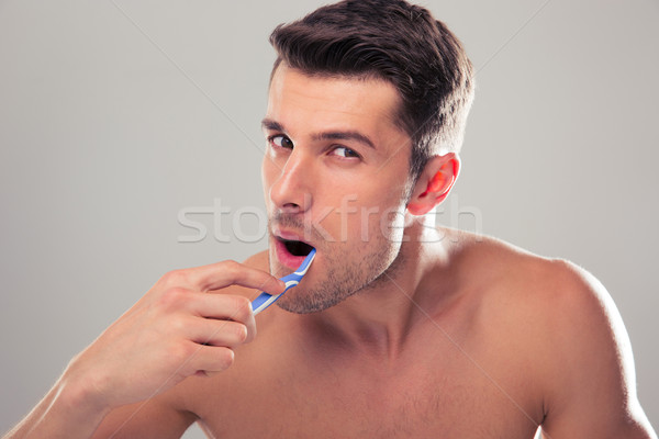 Portrait of a handsome man brushing his teeth Stock photo © deandrobot