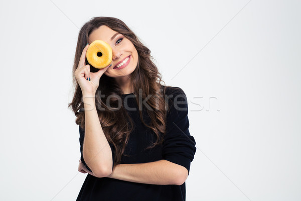 Smiling woman covering her eye with donut Stock photo © deandrobot