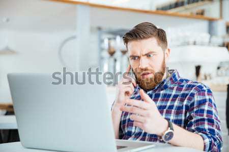 Back view of man using laptope and smartphone Stock photo © deandrobot