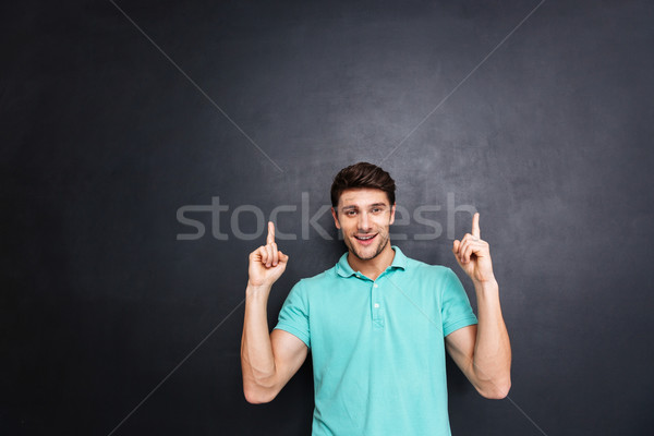 Foto stock: Sorridente · feliz · moço · indicação · para · cima · tanto