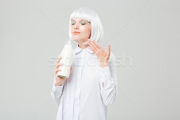 Attractive inspired young woman smelling milk in bottle Stock photo © deandrobot